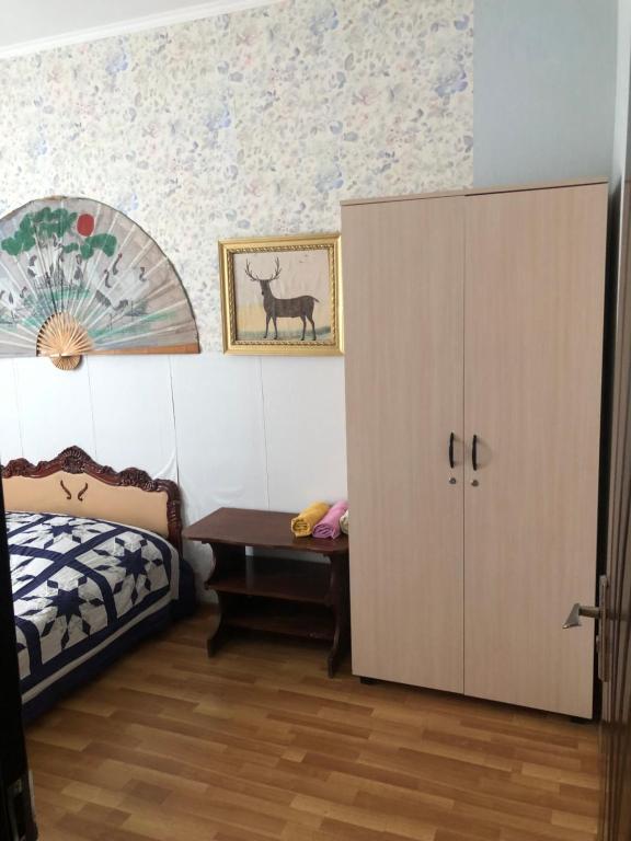 a bedroom with a bed and a desk and a cabinet at Apartment Zaziashvili 30 in Tbilisi City