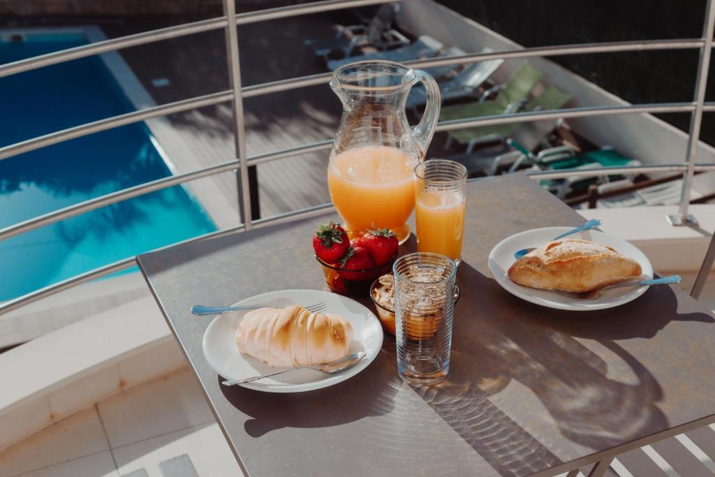 uma mesa com dois pratos de comida e dois copos de sumo de laranja em Eucalyptus - The Apartment em Olhos de Água