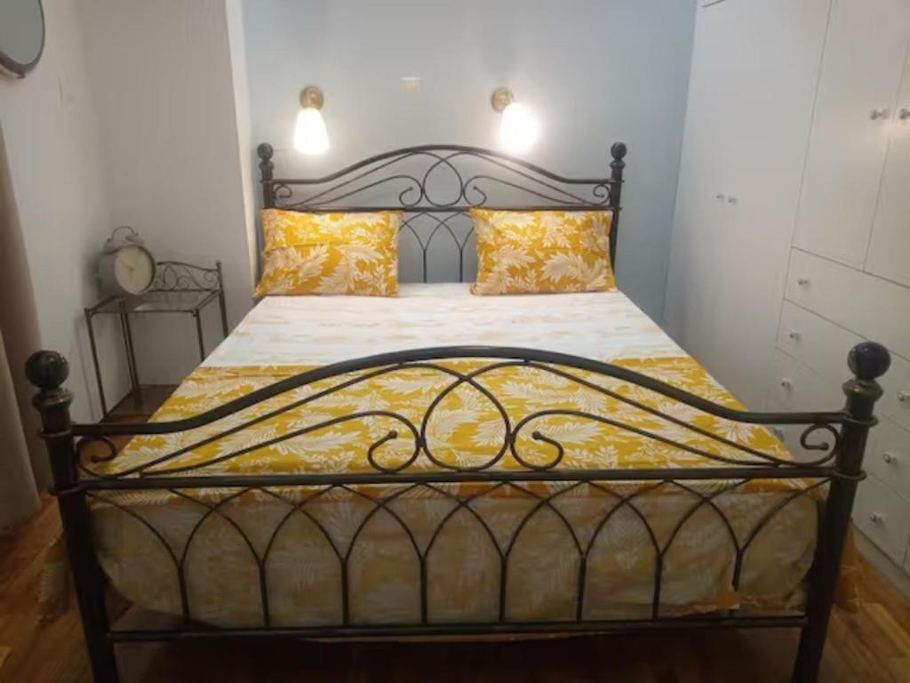 a bedroom with a black bed with yellow pillows at Freatida apartment in Piraeus