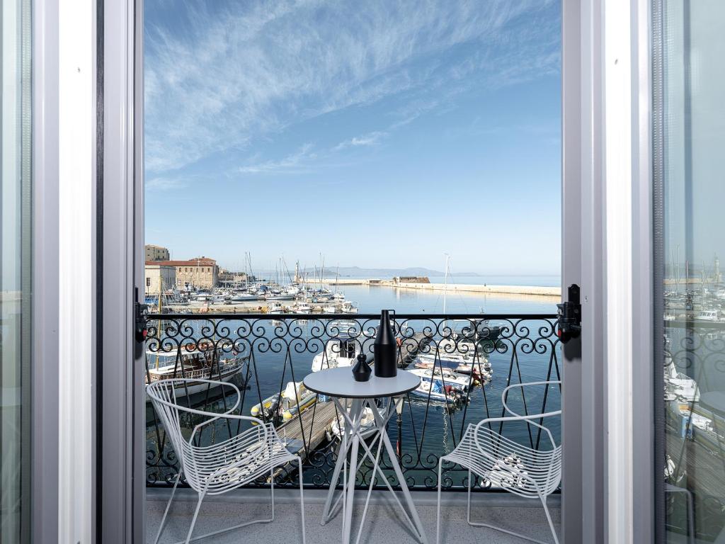 balcón con mesa y sillas y vistas al puerto en Riviera Suites en La Canea