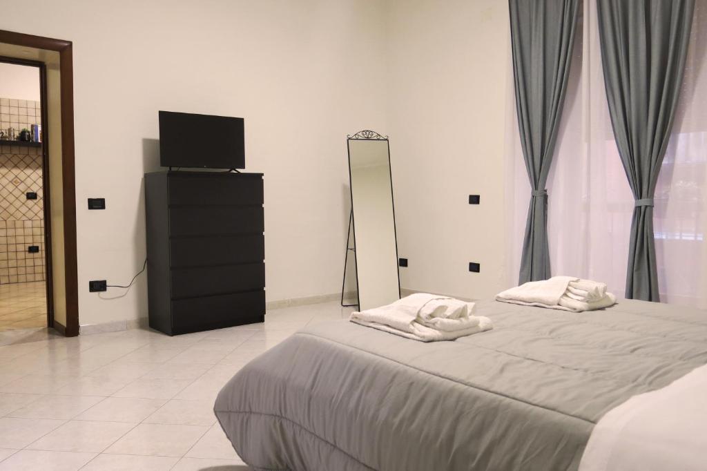sypialnia z łóżkiem i komodą z lustrem w obiekcie Maison Agnone w mieście Neapol