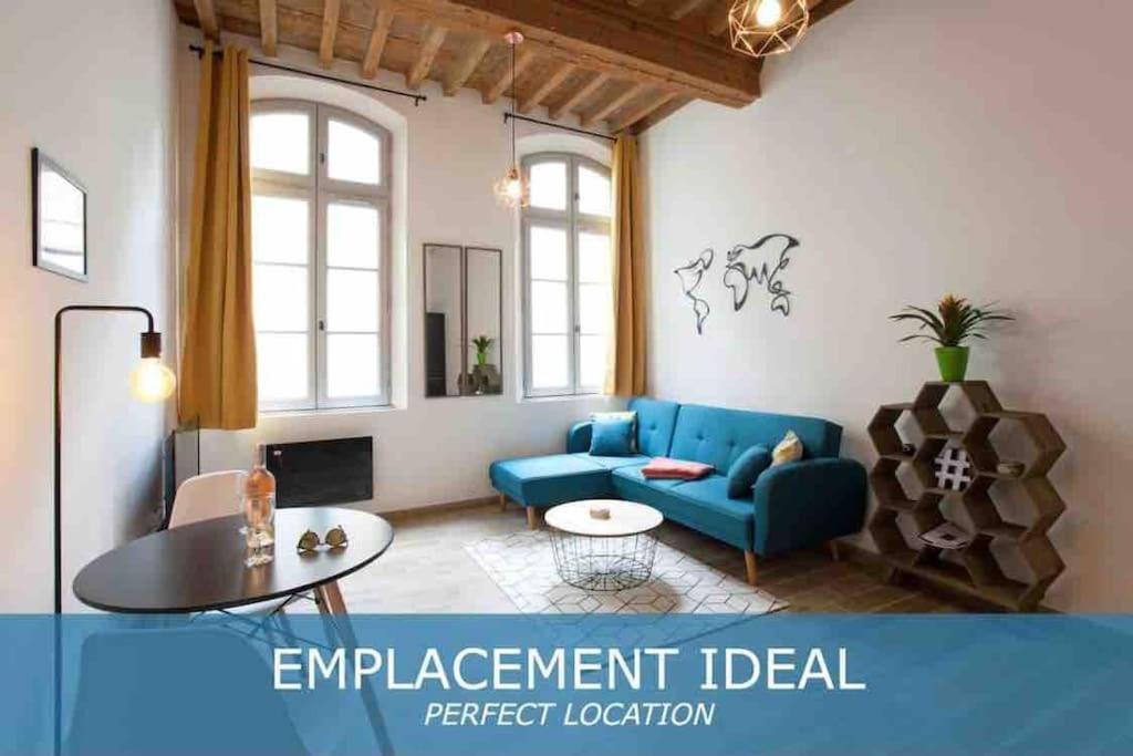 salon z niebieską kanapą i stołem w obiekcie Appartement lumineux en centre-ville w mieście Arles