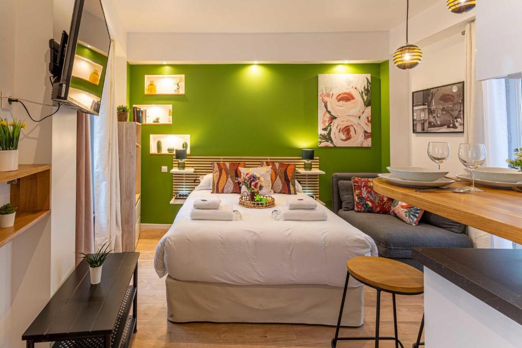una camera con un grande letto e una parete verde di Cosy Studio - 2P- Beauregard - 3 a Parigi