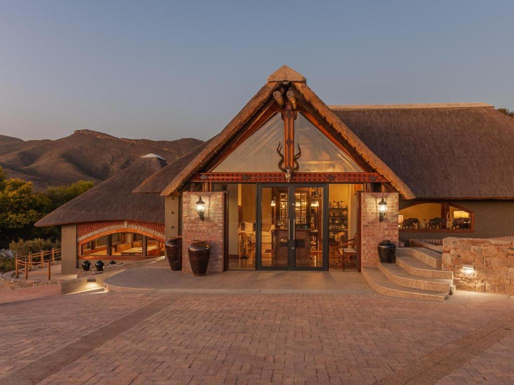 a building with a thatched roof with a patio at Mont Eco Game Reserve in Montagu
