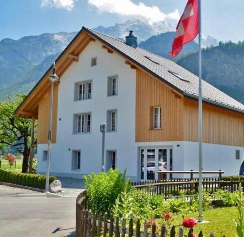 a building with a flag in front of it at mountain-panorama EG 2-Bettwohnung in Meiringen