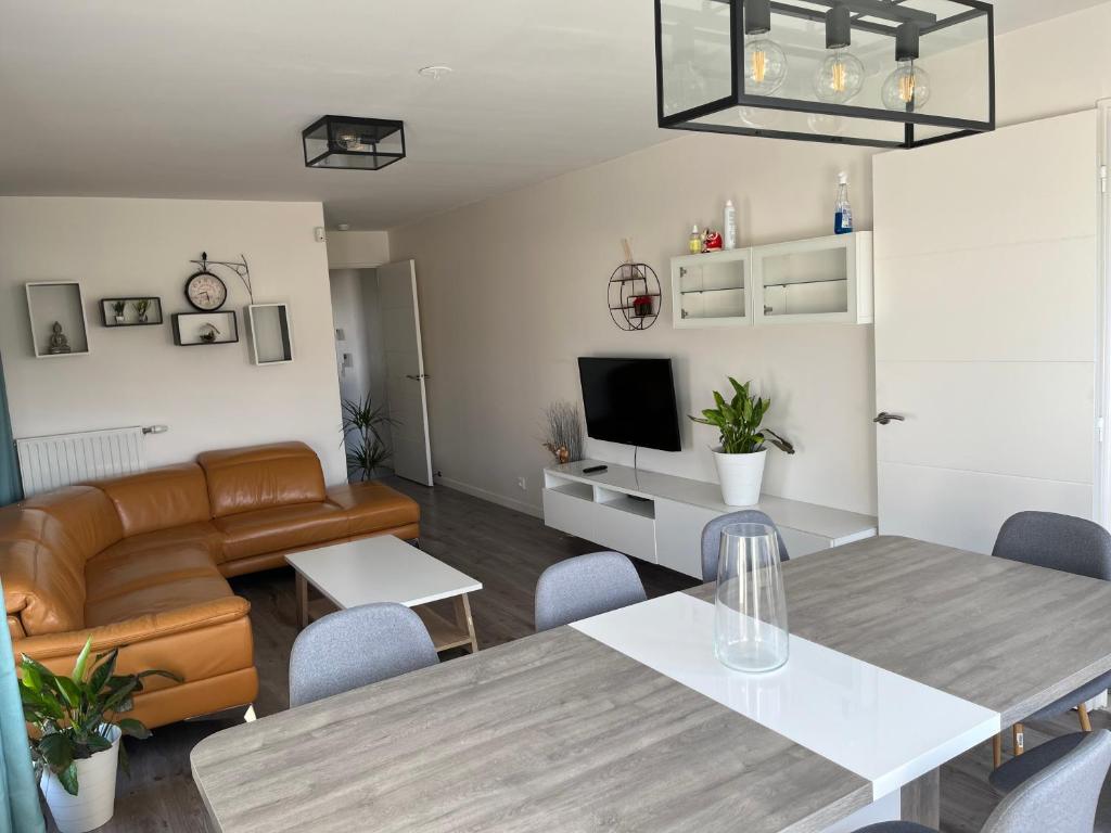 a living room with a table and a couch at Appartement de Romainville in Romainville