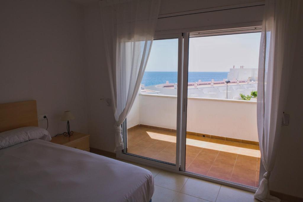 a bedroom with a bed and a view of the ocean at Duplex Ancla in L'Ametlla de Mar