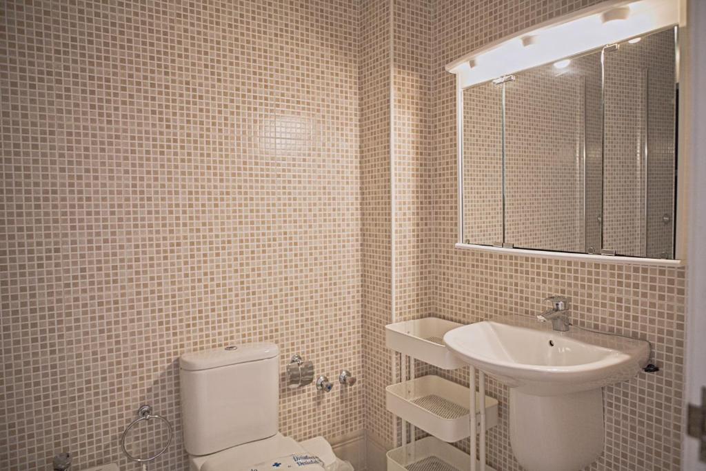 a bathroom with a white toilet and a sink at Duplex Ancla in L'Ametlla de Mar