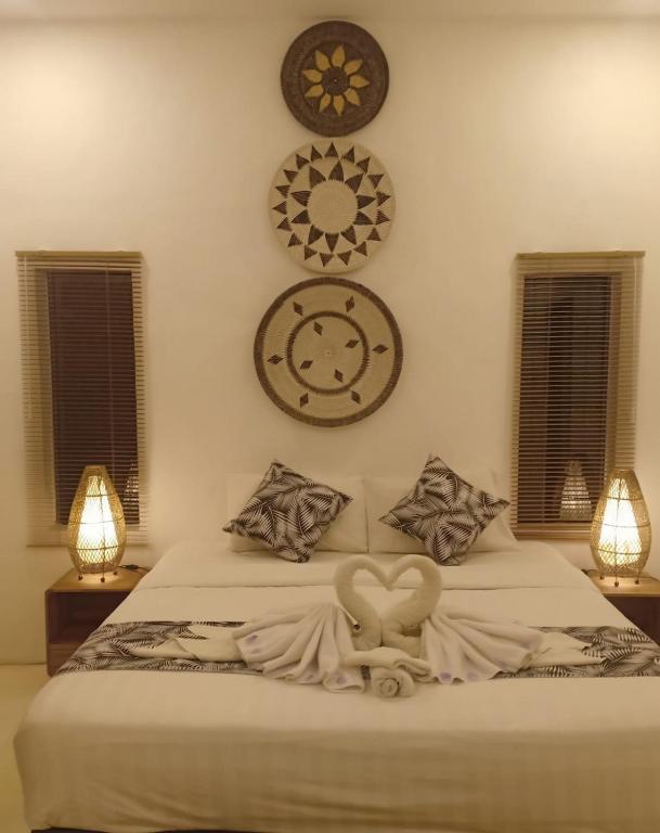 a bedroom with a bed with clocks on the wall at DIRGA apartement Bali in Canggu