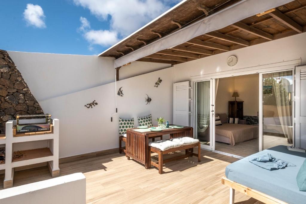 Zimmer mit einem Balkon, einem Bett und einem Schreibtisch. in der Unterkunft Casa Juleta in Playa Blanca