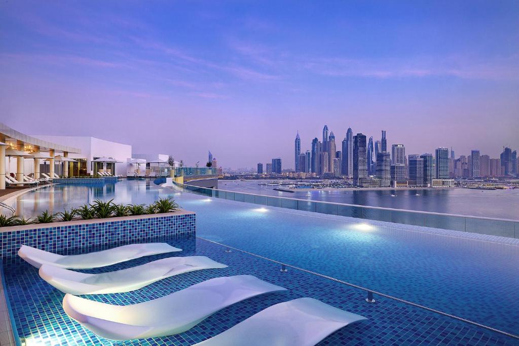 una piscina dell'hotel con vista sulla città di NH Collection Dubai The Palm a Dubai