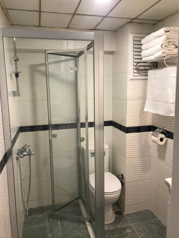 een badkamer met een toilet en een glazen douche bij CLASS SUİT RESİDENCE in Canakkale
