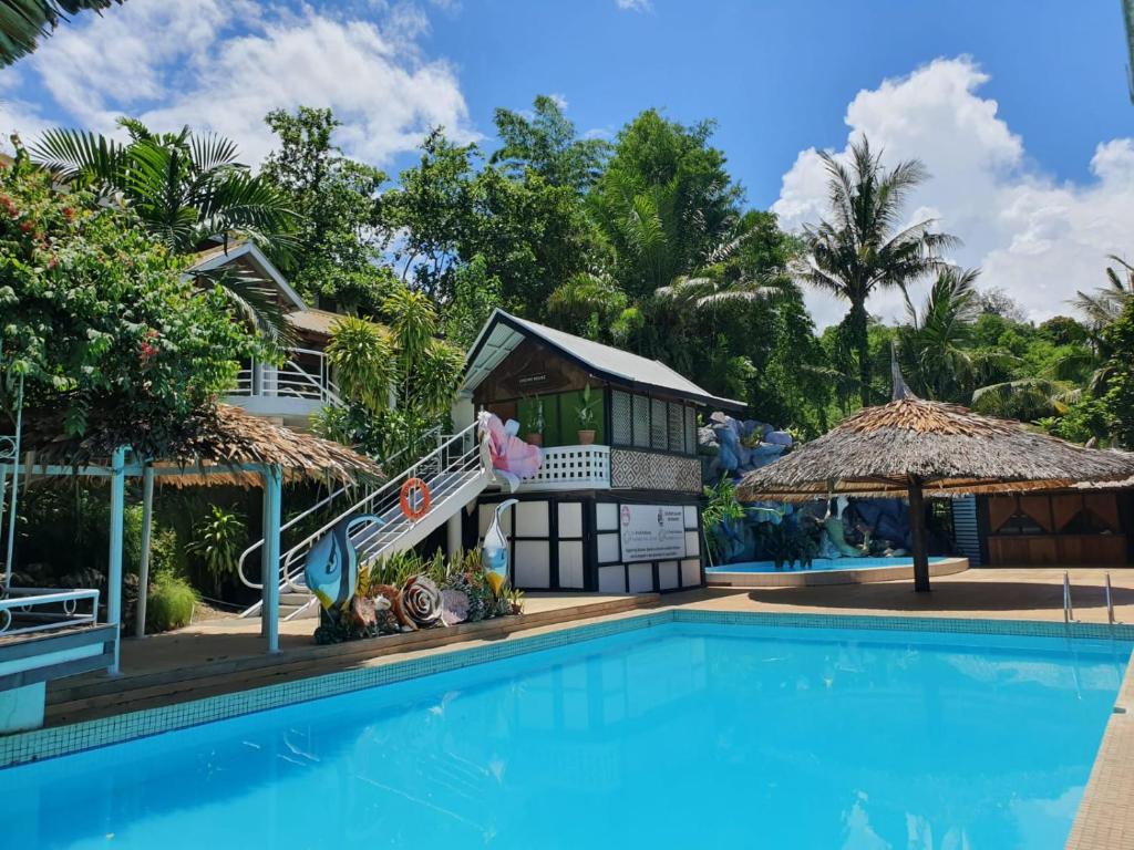 a resort with a swimming pool and a house at Honiara Hotel in Honiara