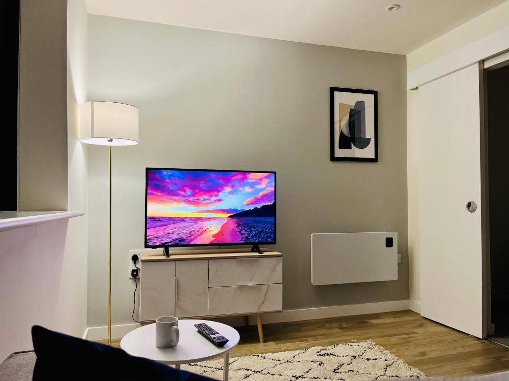 a living room with a flat screen tv on a wall at Fantastic one bedroom apartment near Old Trafford Stadium in Manchester