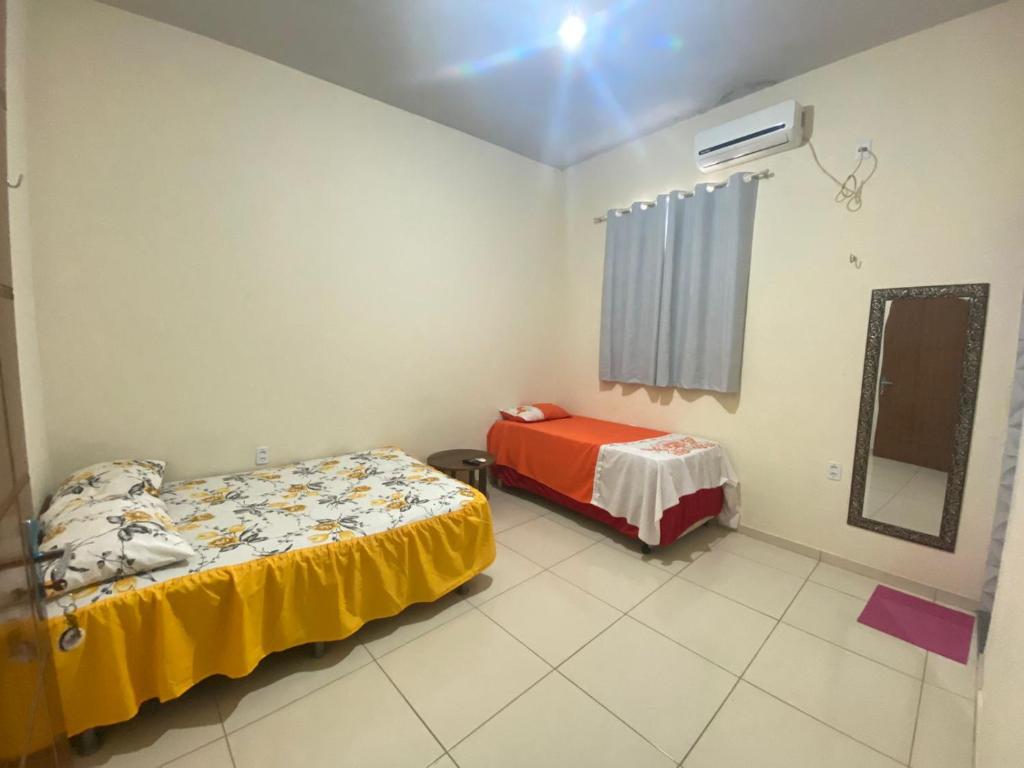 een kamer met 2 bedden en een spiegel bij Pousada Mineira in Barreirinhas