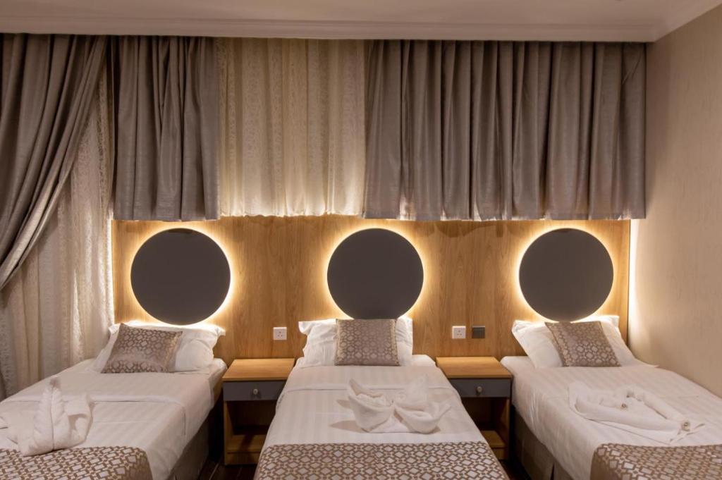 duas camas num quarto com espelhos na parede em بيوتات الحور em Taif