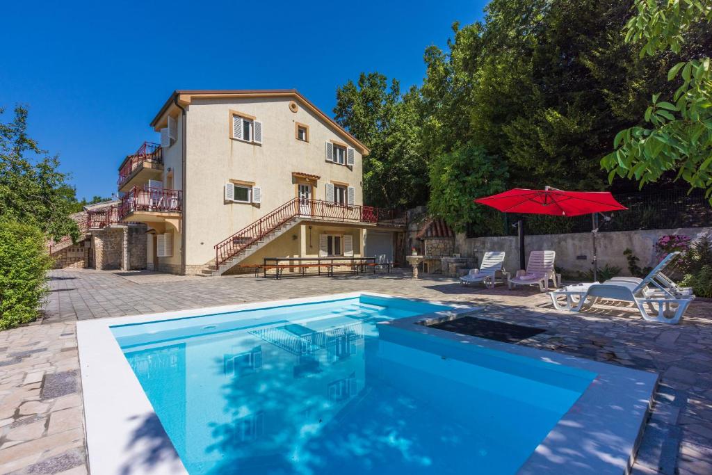 a large swimming pool in front of a house at Apartments NEVEN in Grižane