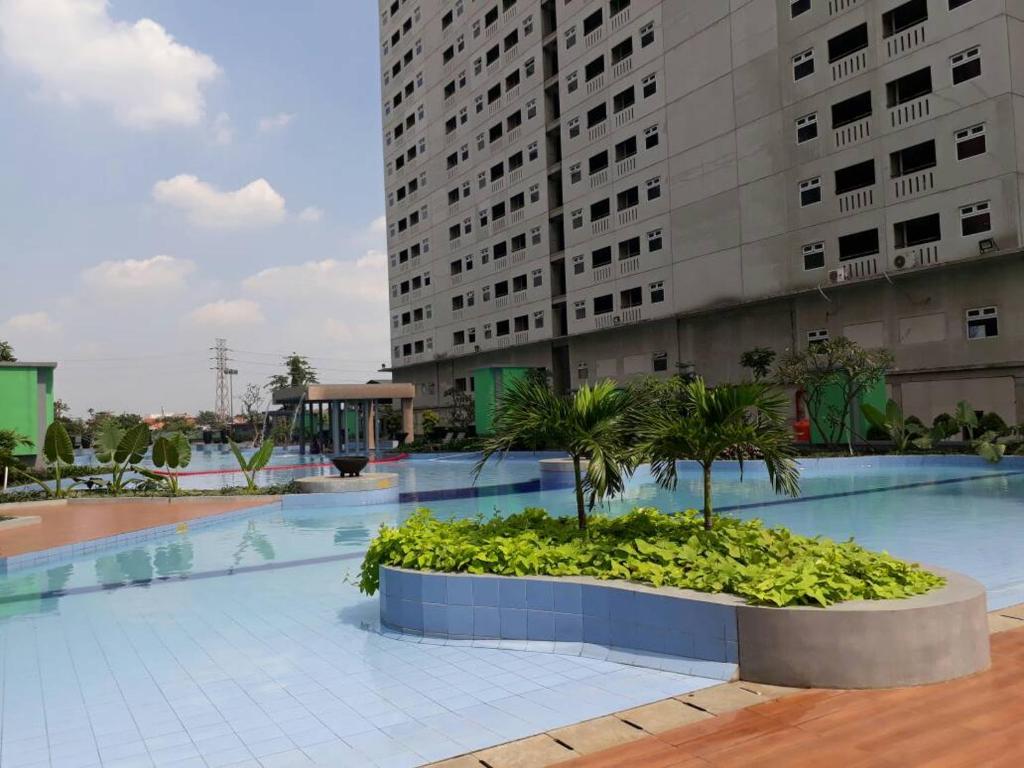 una gran piscina con un gran edificio en Green Pramuka City, en Yakarta