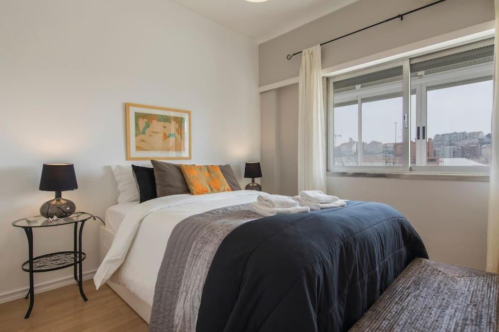 una camera con un grande letto e una finestra di 131 A - Castle View Balcony a Lisbona