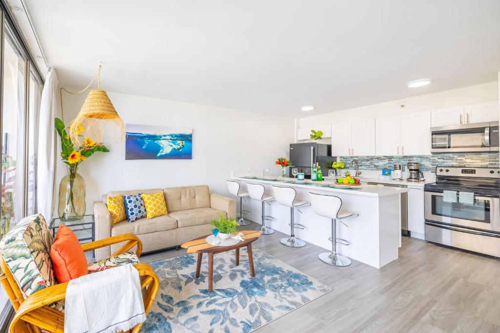 a living room with a couch and a kitchen at Remodeled 1BR Condo, Ocean Views with Free Parking! in Honolulu