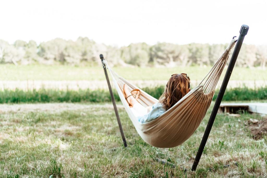a woman laying in a hammock in a field at Saint Paul le Marseillais Gites in Mèze
