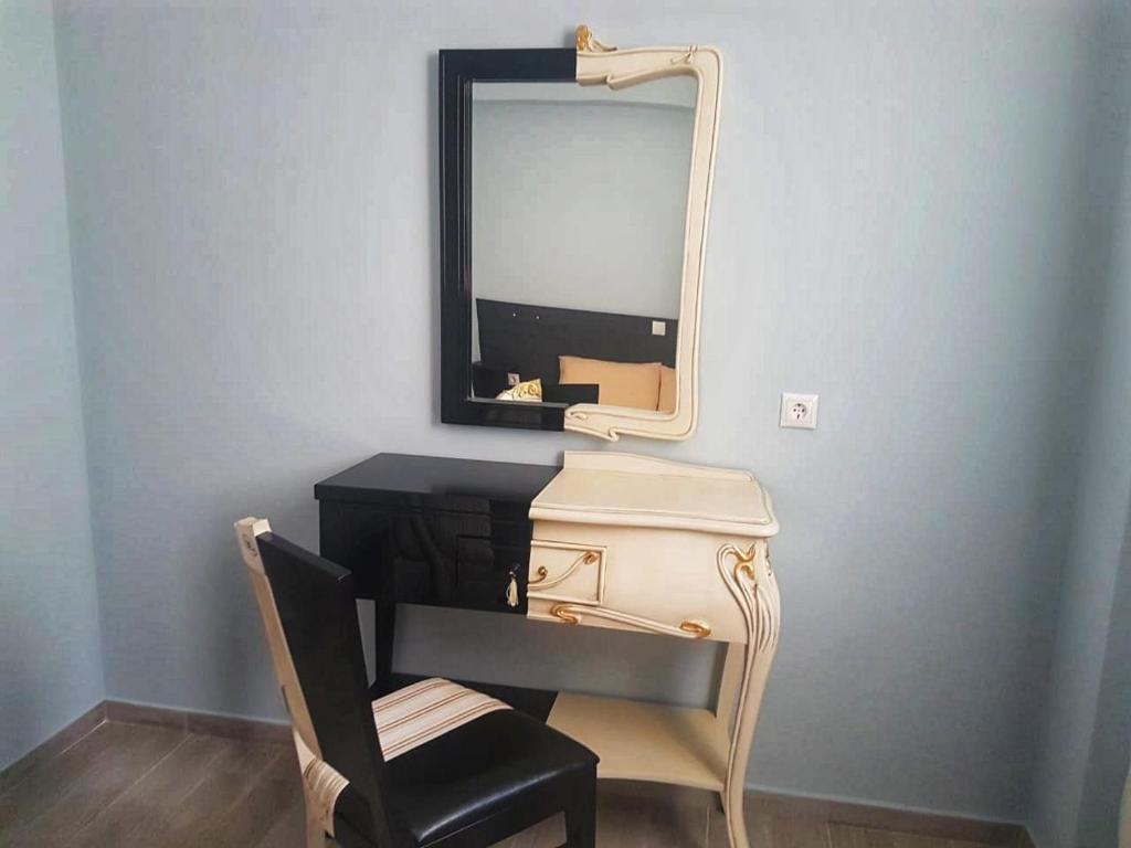 a vanity with a chair and a mirror on a wall at Studio Beleri in Himare