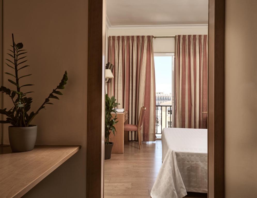 a hotel room with a bed and a balcony at Strada Marina Hotel in Zakynthos