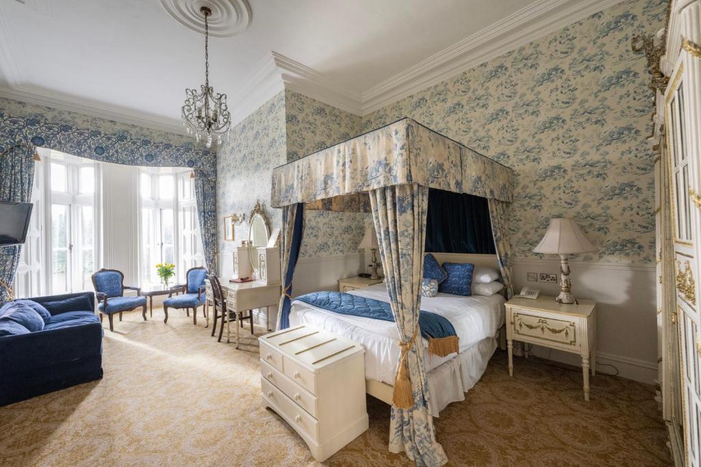 Belleek Castle, Ballina في بالينا: غرفة نوم بسرير مظلة وورق جدران زرقاء