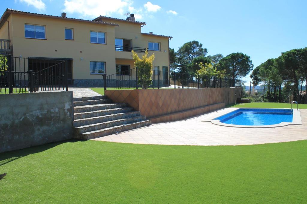 a house with a swimming pool in a yard at Villa Galicia in Lloret de Mar