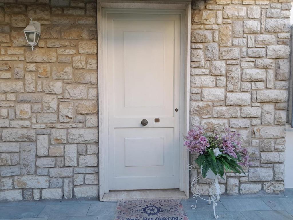 una puerta blanca de un edificio de ladrillo con un jarrón de flores en Villetta Liana Apuana Mare en Lido di Camaiore