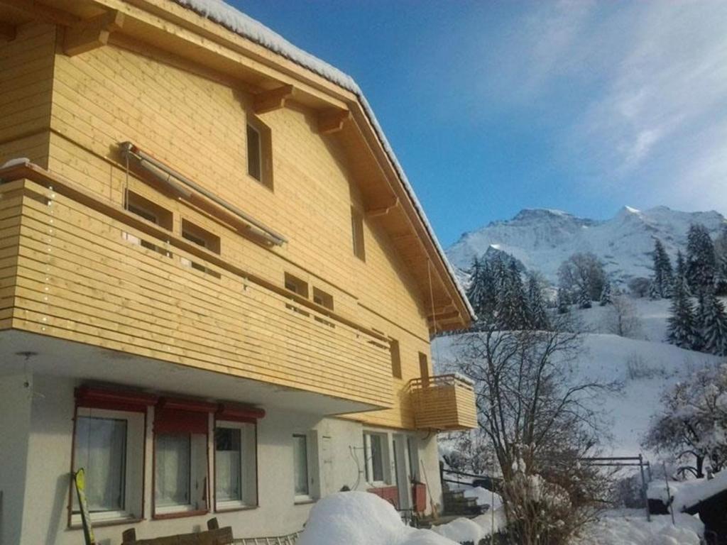 ein Haus im Schnee mit Bergen im Hintergrund in der Unterkunft Viola 2 Bett Wohnung in Wengen
