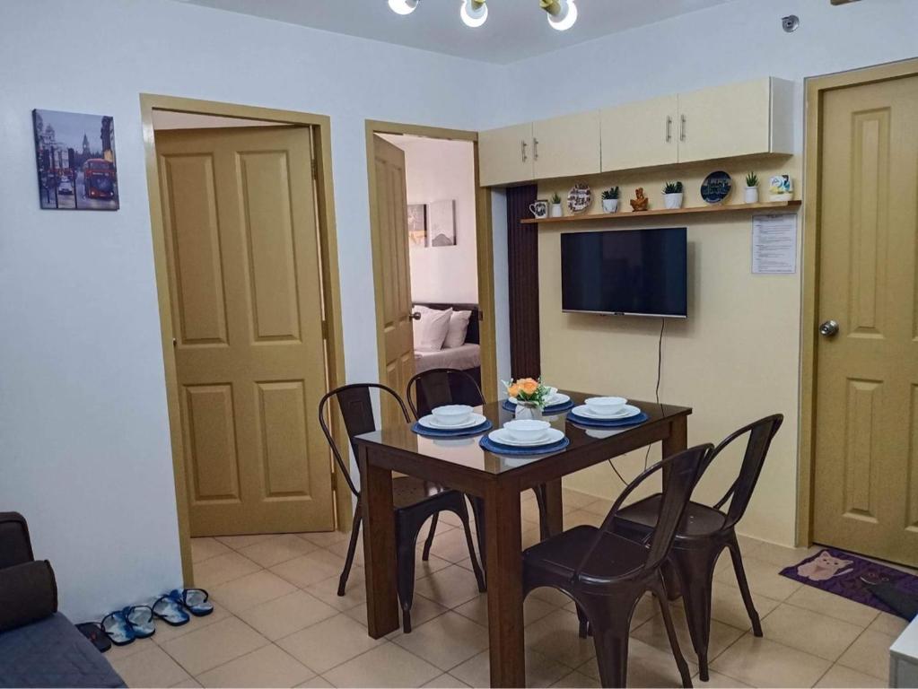 uma cozinha e sala de jantar com mesa e cadeiras em One Spatial Two Bedroom Condominium Unit with Pool and Gym free Netflix and wifi em Iloilo City