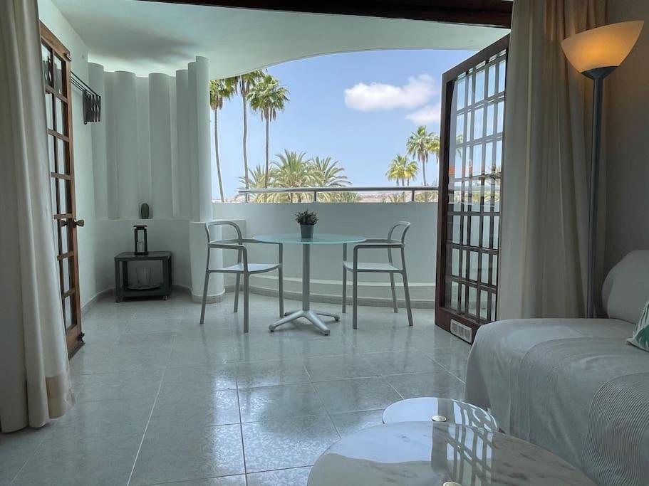 a bedroom with a table and chairs and a balcony at Apartment PM237 - Paraiso Maspalomas in Playa del Ingles