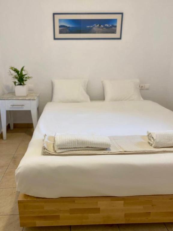 Un dormitorio con una gran cama blanca en una habitación. en San Constantine, en Ornos