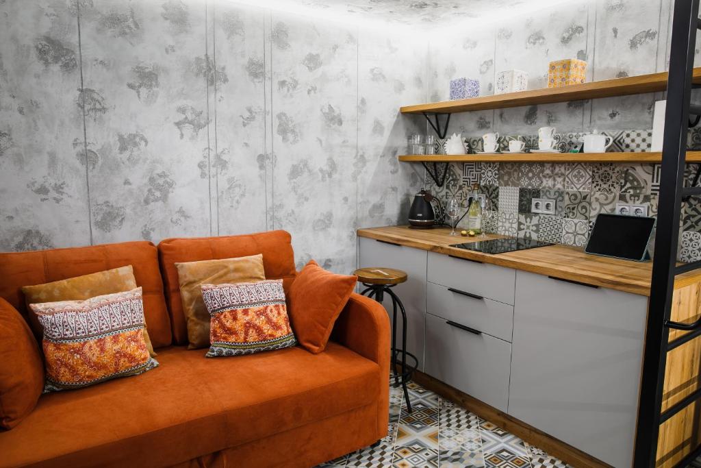 un soggiorno con divano arancione e bancone di Apart 1 Chernivtsy a Černivci
