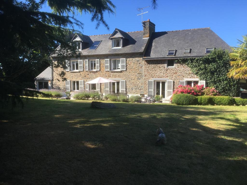 a bird sitting in the grass in front of a house at Nature, Mer, Golf & Decouvertes... in Plouha