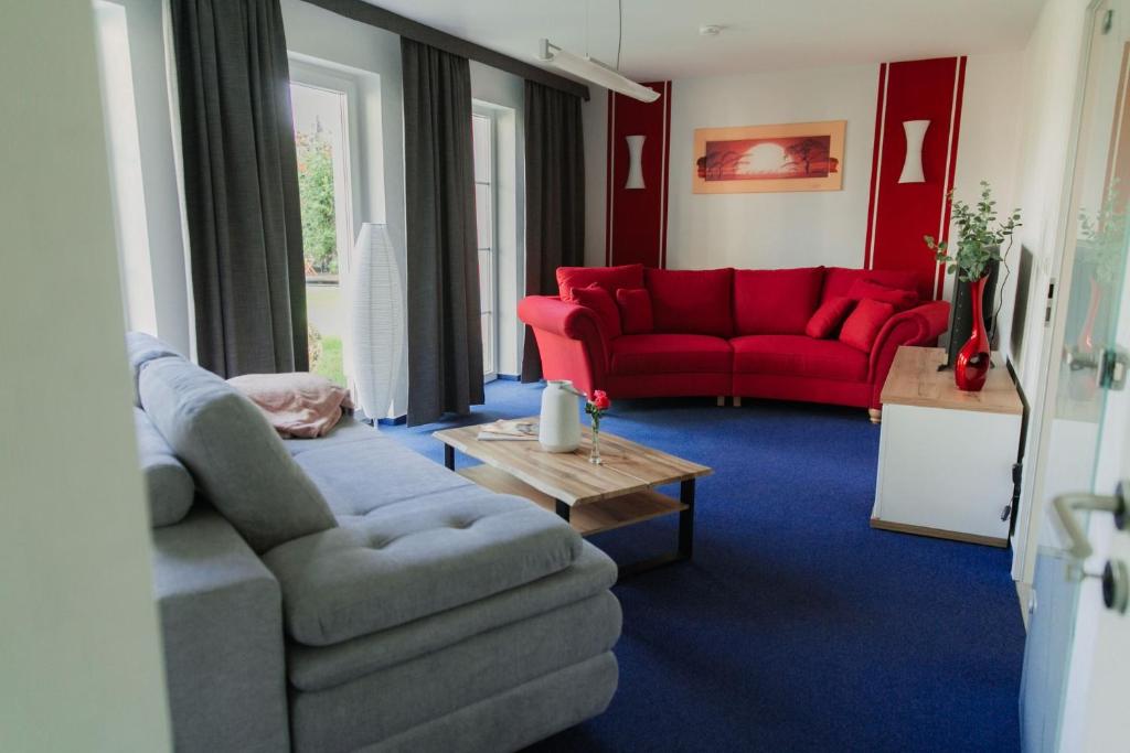 a living room with a couch and a red couch at Ferienhaus LORINI in Kolkwitz