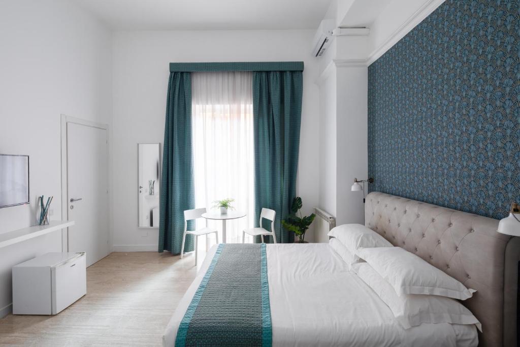 a bedroom with a large bed with a blue wall at Trevi Fountain Guesthouse in Rome