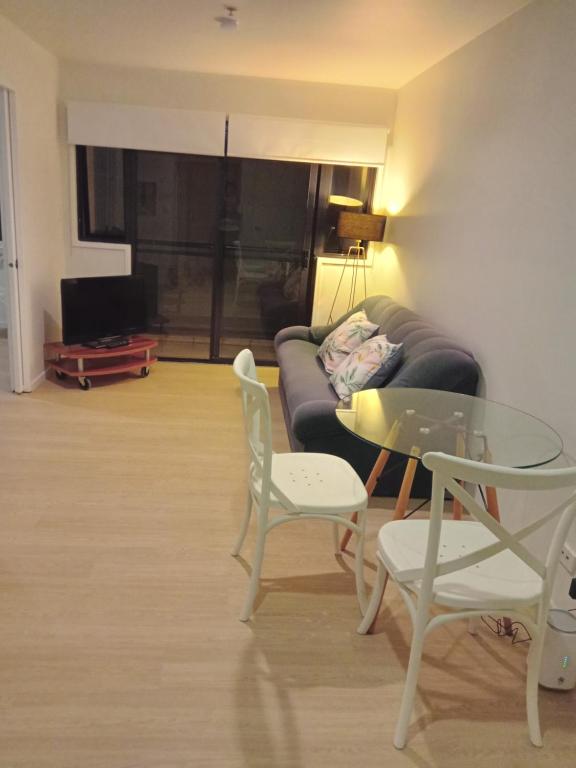 a living room with a couch and a table and chairs at Central one bedroom apartment in Auckland
