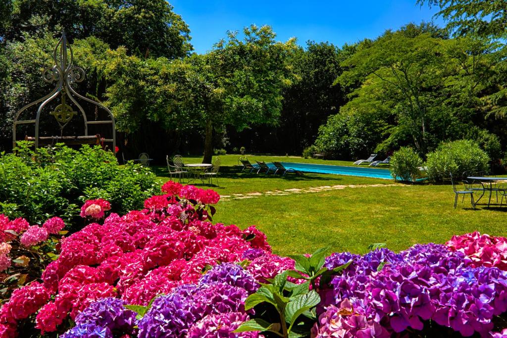 un jardín con flores rosas y moradas y una piscina en Le Pavillon de Kériolet, en Concarneau