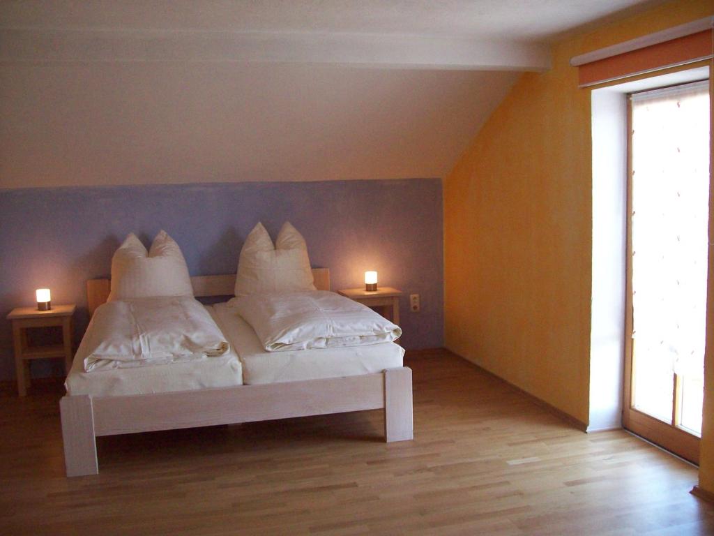 um quarto com uma cama com almofadas brancas em Ferienwohnung Haus Hollerbusch em Zwiesel