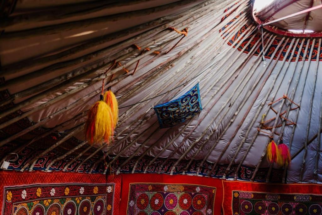um tecto de uma tenda com fios pendurados nela em Nomadic Life in a yurt em Bügat