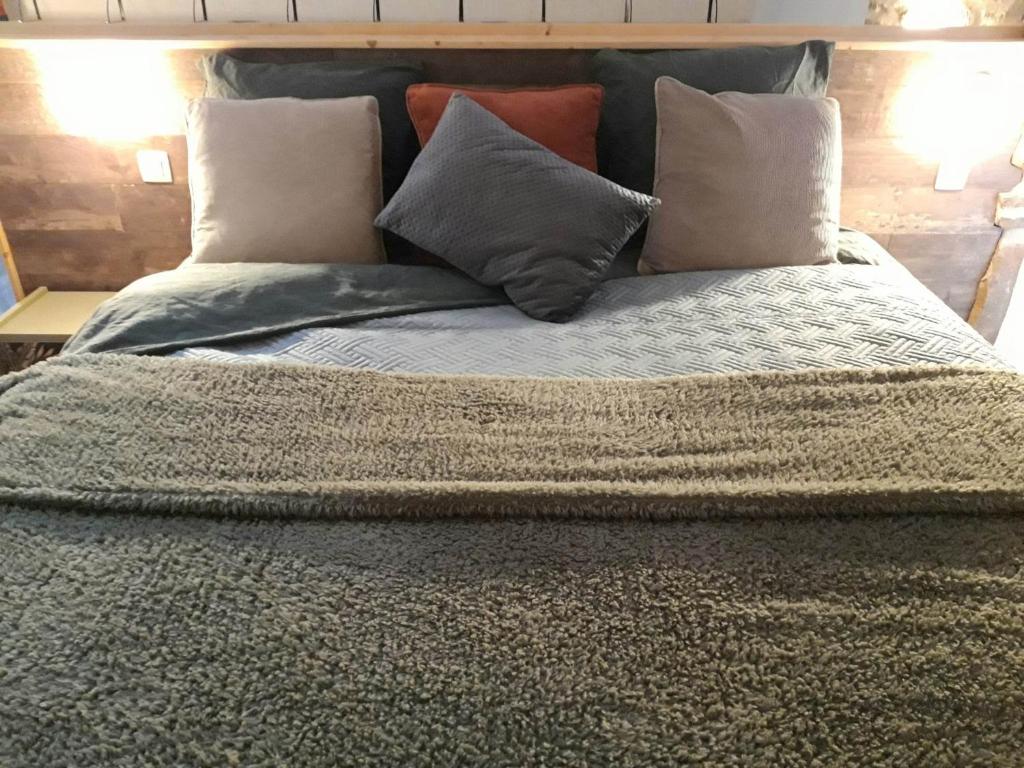 Una cama grande con almohadas encima. en Le Héron ( Gîte ), en Blaimont