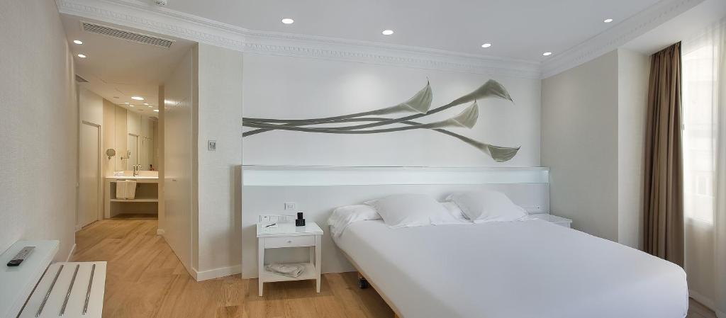 a bedroom with a bed with a painting on the wall at Melia Plaza Valencia in Valencia
