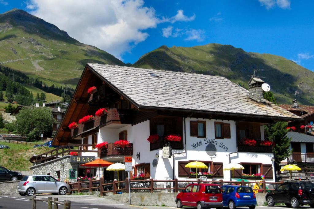 a building in the mountains with cars parked in front at Santa San in Champoluc