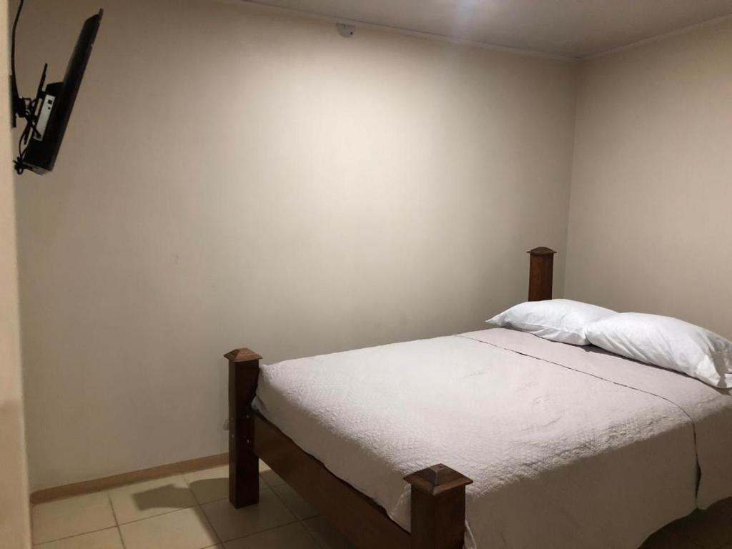 Rivera Family Apartments في Santiago Este: غرفة نوم بسرير ذو شراشف ووسائد بيضاء