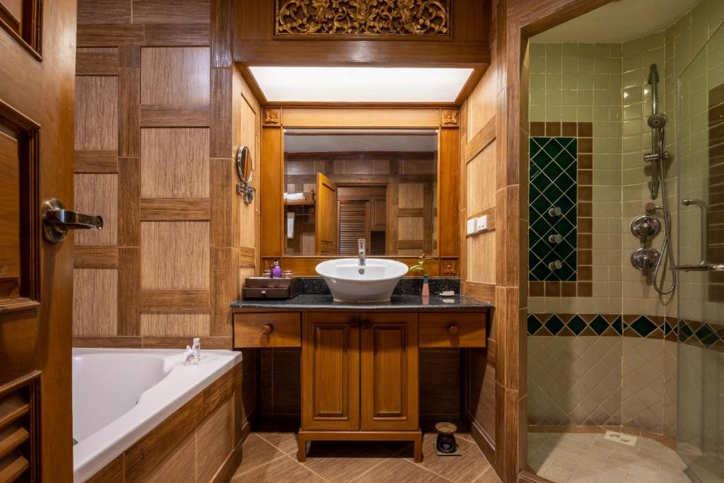 a bathroom with a tub and a sink and a bath tub at Khum Phaya Resort & Spa Boutique Collection in Chiang Mai