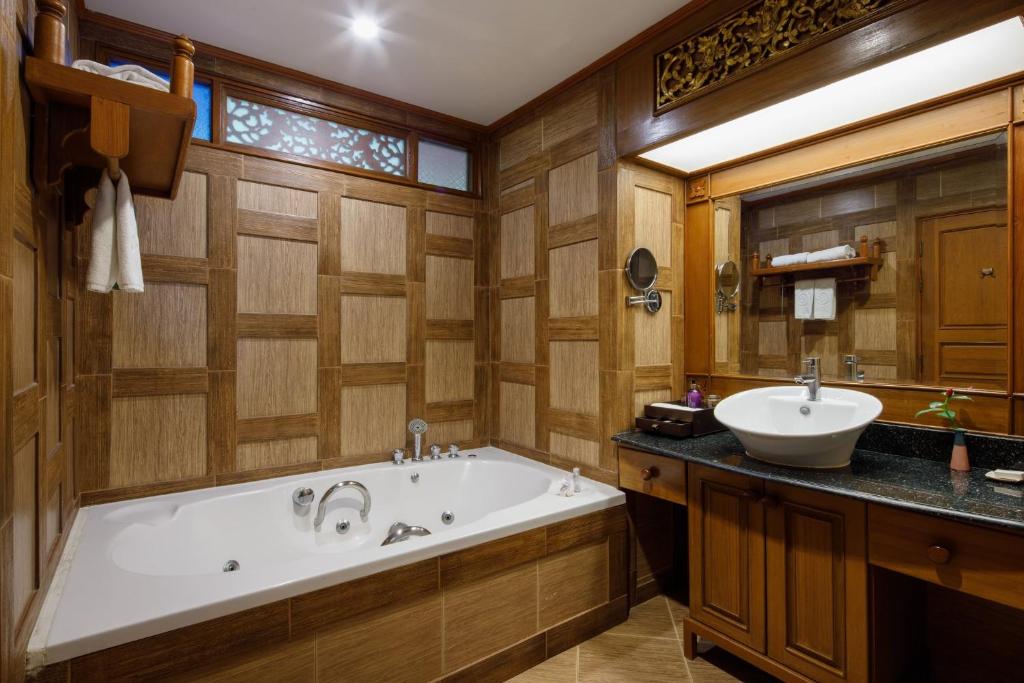 a bathroom with a tub and a sink at Khum Phaya Resort & Spa Boutique Collection in Chiang Mai