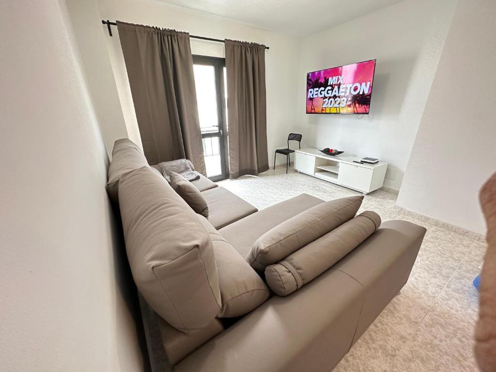 um grande sofá numa sala de estar com televisão em apartment arrecife beyond em Arrecife