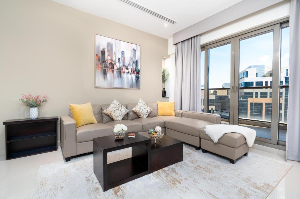 uma sala de estar com um sofá e uma grande janela em White Sage - Elite Residence 1 bedroom em Dubai